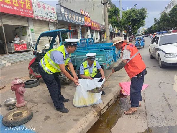 菜油泼洒路面存隐患 民警及时清理保安全.jpg